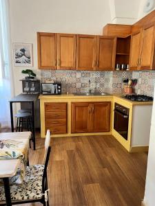 a kitchen with wooden cabinets and a table in a room at Kaléa Gallipoli in Gallipoli