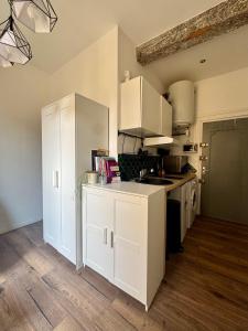 a kitchen with white cabinets and a counter top at Stud'Arles in Arles +1 photo