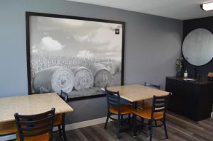 a dining room with two tables and a picture of a field at The Northwest Inn in Spencer