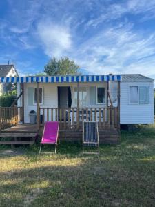 a tiny house with two chairs and a porch at Mobil home 2 chambres tout confort avec terrasse in La Chapelle-sur-Loire
