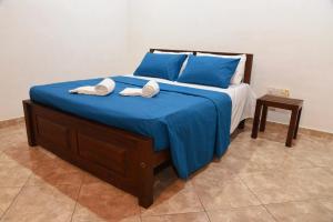 un lit avec des draps bleus et deux serviettes dessus dans l'établissement Belvita Ayurveda Health Resort, à Negombo