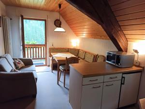 a kitchen and living room with a microwave on a counter at Ferienwohnungen Vogt's Libding in Bad Rippoldsau-Schapbach