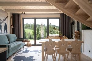 a living room with a couch and a table with chairs at Domki pod Bachledówką in Czerwienne