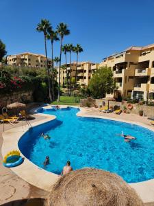 Una gran piscina con gente en un resort. en Green Hill Apartment, en La Cala de Mijas