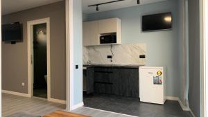 a kitchen with white cabinets and a refrigerator at Міні-готель аквапарку Европа in Solomonovo
