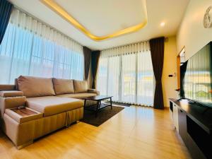 Una sala de estar con un sofá y un televisor. en Krabi Ao Nang PrivateStay Pool villa 2Br, en Ao Nam Mao
