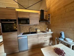 een keuken met houten kasten, een wastafel en een fornuis bij La Bergerie in Luz-Saint-Sauveur