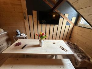 een houten tafel met een vaas met bloemen in een kamer bij La Bergerie in Luz-Saint-Sauveur