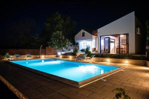 a swimming pool in a backyard at night at Villa Tia in Mostar