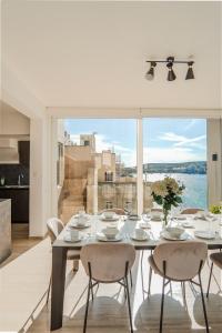 comedor con mesa con sillas y ventana grande en House of Luxury with Pool by Solea, en St Paul's Bay