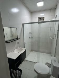 a bathroom with a toilet and a sink and a shower at Casa da piscina in Macapá +19 photos