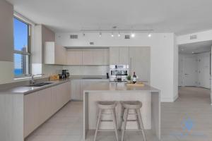 una cocina con una isla grande con 2 taburetes en High-Floor with Stunning Views-Luxury Condo - Pools, en Hollywood