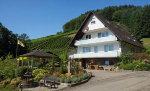 a large white building with a bunch of plants in front at Ferienwohnung Baßler in Kappelrodeck