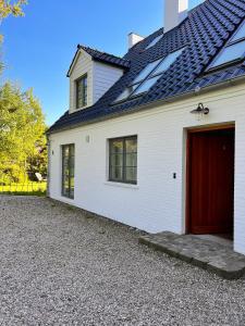 una casa blanca con un garaje rojo en Sommerby Sky, en Brodersby 19 fotos más