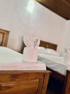 a towel sitting on top of a bed at Amelia Beach Cottages in Wadduwa