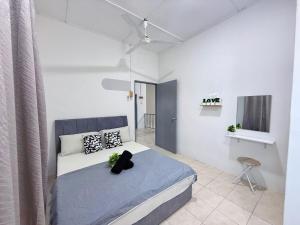 Un dormitorio con una cama en una habitación blanca. en Outdoor BBQ Air Putih 4R3B Homestay, en Kuantan