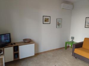 a living room with a tv and a couch at Appartamento MaRi con piscina in Torre Lapillo