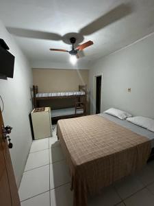 a bedroom with a bed and a ceiling fan at Residencial Sol Nascente in Porto Seguro +8 photos