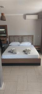 a bed with white sheets and pillows in a bedroom at Petrino 2 semibased by Vasileia in Sarti