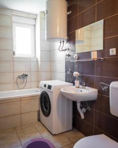 Un baño con lavadora y lavabo. en Apartman RiS, en Trebinje