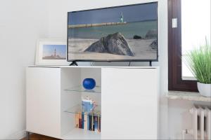 a white cabinet with a television on top of it at Haus Hüttmann Sonnenblüte in Gremsmühlen