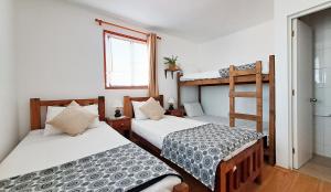 two beds in a room with a bunk bed at Casa Valparaluz in Valparaíso