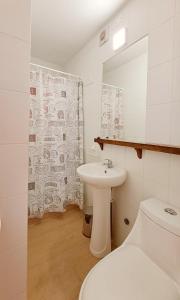 a bathroom with a sink and a toilet and a mirror at Casa Valparaluz in Valparaíso