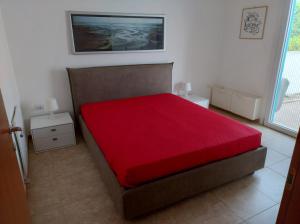 a bedroom with a bed with a red blanket at Appartamento MaRi con piscina in Torre Lapillo +23 photos