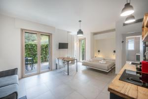 eine Küche und ein Wohnzimmer mit Sofa und Tisch in der Unterkunft ApartmentsGarda - Eleonora Studio 7 in Garda