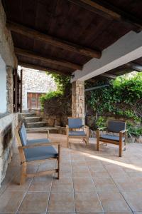 three chairs on a patio with a stone wall at Lazulino Suite by Klodge in Olbia +35 photos