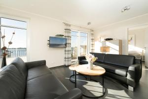un salon avec un canapé et une table dans l'établissement Strandresidenz Vogelflug Penthouse 14, à Fehmarnsund 38 autres photos