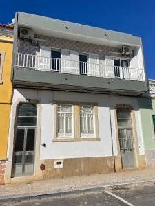 a building with a balcony on top of it at Casa da Baixa in Faro