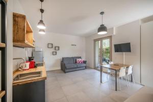 eine Küche und ein Wohnzimmer mit einem Tisch und einer Couch in der Unterkunft ApartmentsGarda - Eleonora Studio 7 in Garda