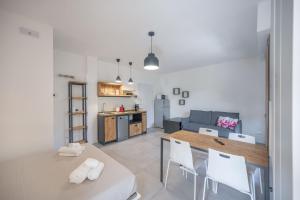 eine Küche und ein Wohnzimmer mit Tisch und Stühlen in der Unterkunft ApartmentsGarda - Eleonora Studio 7 in Garda