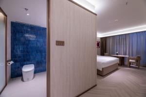 a bedroom with a bed and a table in a room at 桔子水晶上海江桥万达酒店 in Shanghai