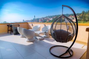 a balcony with white chairs and a hanging basket at Kigali Paramount Hotel in Kigali