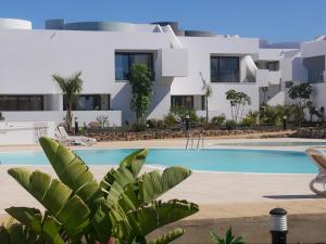 a villa with a swimming pool in front of a building at Oasis in paradise with pool in La Oliva