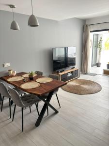 une salle à manger avec une table, des chaises et une télévision dans l'établissement Oasis in paradise with pool, à La Oliva