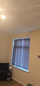 a window in a room with blinds on it at Cosy 3 bedroom house in Leigh