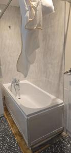 a bath tub with a faucet in a bathroom at Cosy 3 bedroom house in Leigh