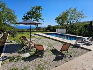 a group of chairs and an umbrella next to a pool at Villa LuceSole Budva in Budva