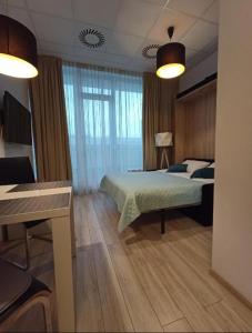 a bedroom with a bed and a desk in it at Zlatarooms 409 in Warsaw