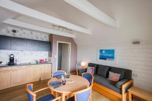 a living room with a table and a couch at Tipoz'immo-Le Grand Grand 210 -view and direct access to the sea-pets accep in Pouldreuzic