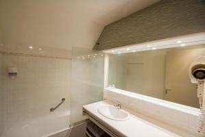 a bathroom with a sink and a tub and a mirror at Tipoz'immo-Le Grand Grand 210 -view and direct access to the sea-pets accep in Pouldreuzic +7 photos
