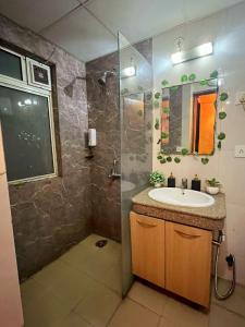 诺伊达Palm Breeze Luxury Studio Apartment的带水槽和淋浴的浴室