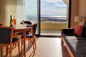 a dining room with a table and a couch at Tipoz'immo-Le Grand Grand 209 -view and direct access to the sea-pets accep in Pouldreuzic
