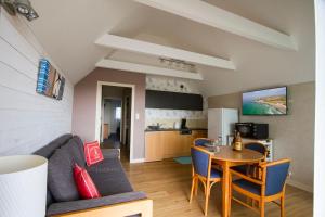 a living room with a couch and a table at Tipoz'immo-Le Grand Grand 209 -view and direct access to the sea-pets accep in Pouldreuzic