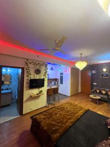 诺伊达Palm Breeze Luxury Studio Apartment的一间带大床的客厅和一间厨房