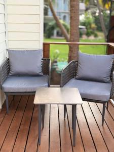 two wicker chairs and a coffee table on a porch at Sea Breeze, Guhagar in Guhagar