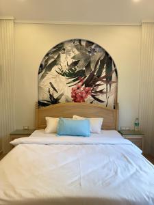 a bedroom with a large bed with a painting on the wall at Sea Breeze, Guhagar in Guhagar